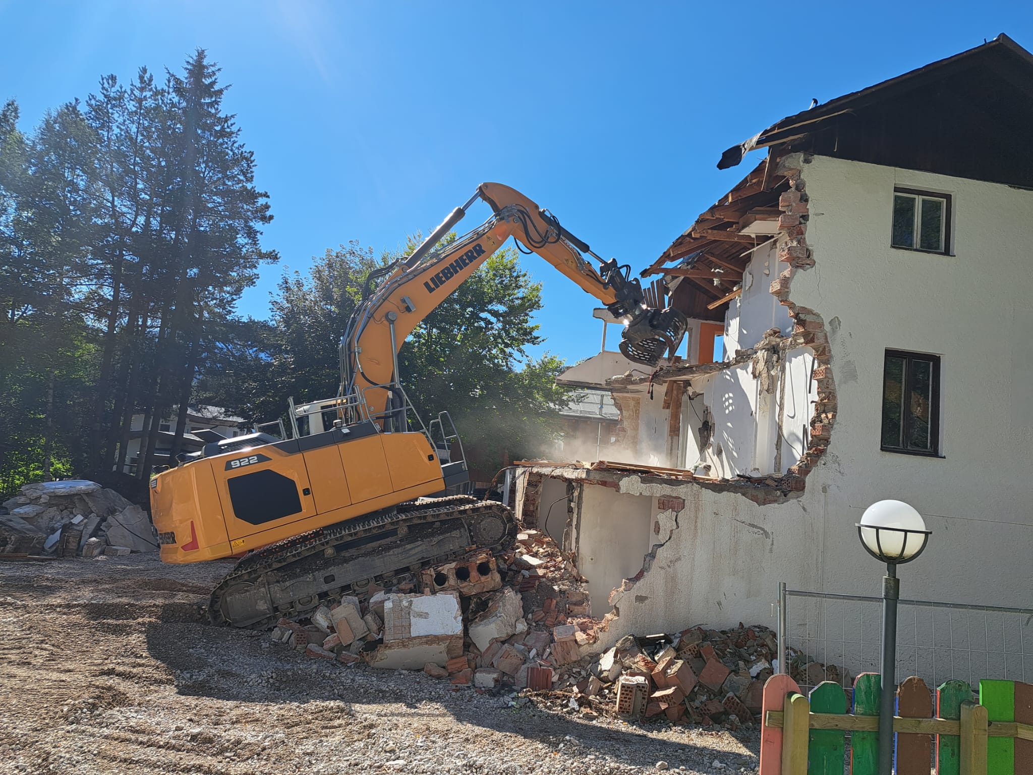 Bagger mit Abbruchgreifer beim Abbruch eines Gebäudes.